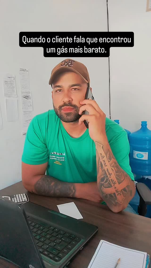 Atendente real da SJ Gás falando ao telefone no balcão, com galões de água ao fundo.